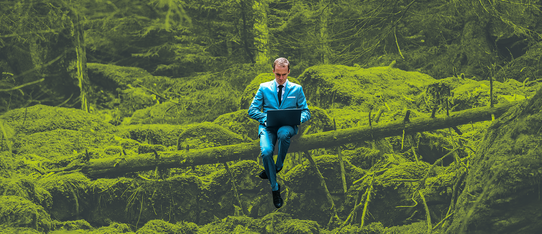 ein Mann in blauem Anzug sitzt auf einem umgefallenen grünen Baum