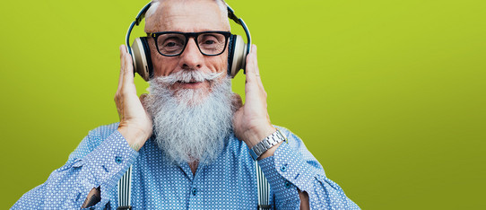 alter Mann mit langem grauen Bart und Kopfhörern